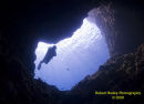 Diver in cave entrance at Capo Figari